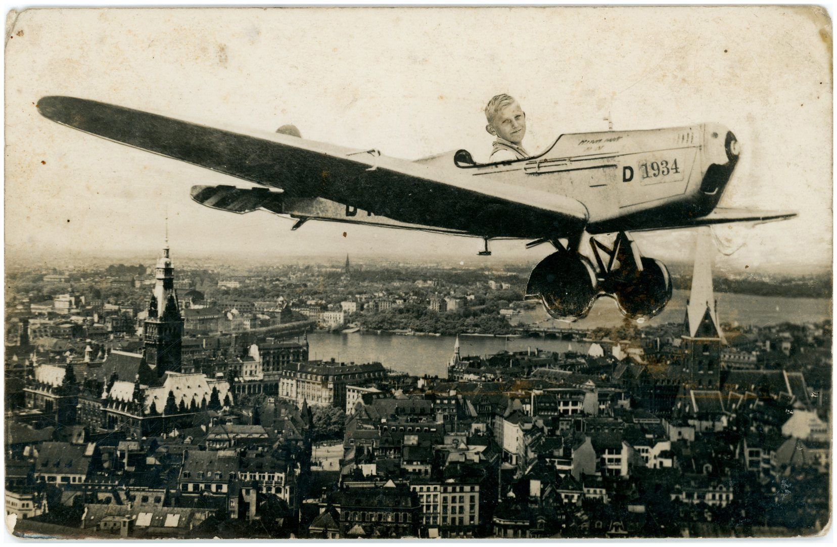Junge in einer historischen Flugzeugmontage vor dem Stadtpanorama von Hamburg