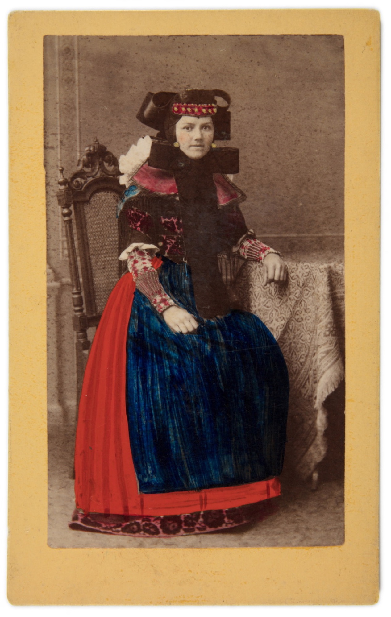 Handkolorierte historische Fotografie einer
sitzenden Frau in Bückeburger Tracht aus dem Atelier
Gustav David in Bückeburg