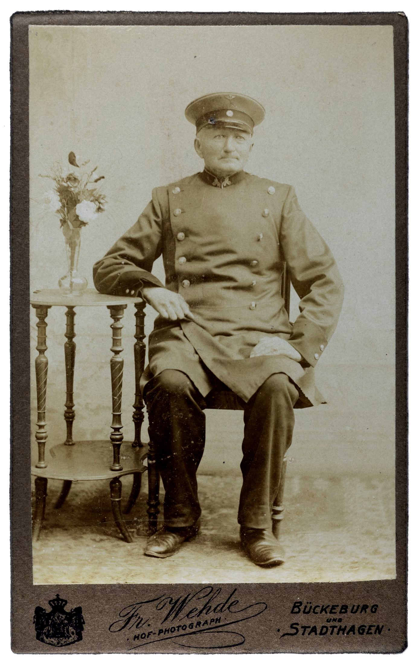 Porträt eines sitzenden Postbeamten in Uniform, Atelier Friedrich Wehde
