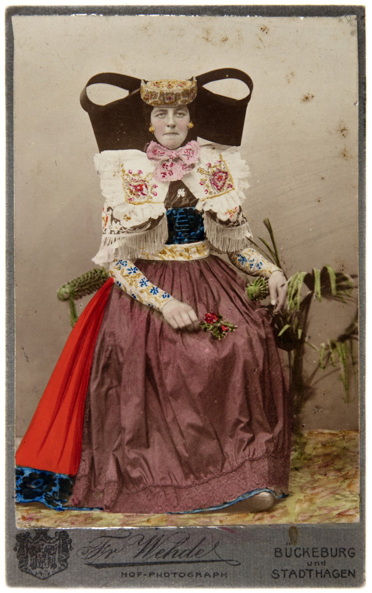 Handkoloriertes Porträt einer sitzenden Frau in Bückeburger Tracht mit Blumen aus dem Atelier Friedrich Wehde