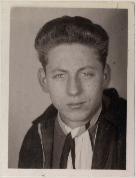 Junge mit Schlips vor einem glatten hellgrauen Hintergrund